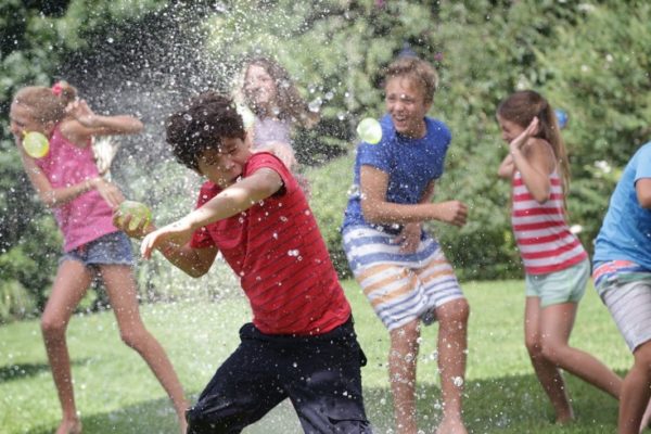 children having water balloon fight